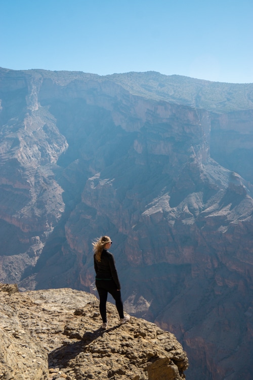 Ikzelf op een rots met uitzicht op Jebel Shams tijdens de Balcony Walk