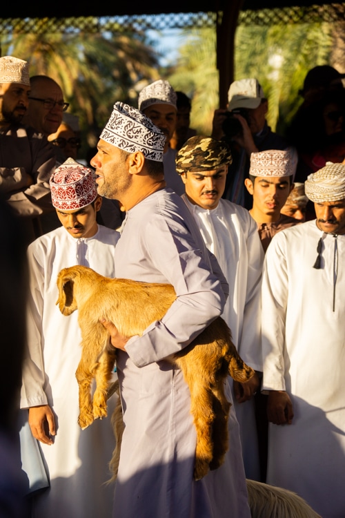 Man met geit op de geitenmarkt in Nizwa, Oman